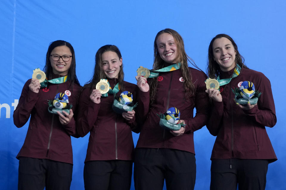 Canada's swimmers Hannah MacNeil, Katerine Savard, Brooklyn Douthwright and Maria-Sophie Harvey pose with their gold medals on the podium of the women's 4x100-meters freestyle relay at the Pan American Games in Santiago, Chile, Saturday, Oct. 21, 2023. (AP Photo/Fernando Vergara)