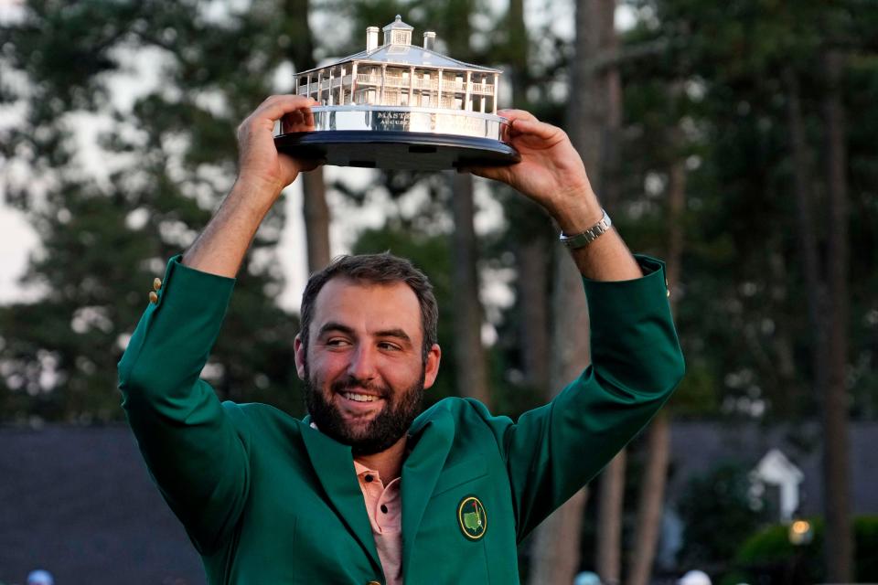 Scottie Scheffler holds the Masters Trophy high at the Green Jacket Ceremony early Sunday evening after winning the tournament.