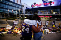 Fans pay their respects at a memorial for Kobe Bryant in front of Staples Center, Tuesday, Jan. 28, 2020, in Los Angeles. Bryant, the 18-time NBA All-Star who won five championships and became one of the greatest basketball players of his generation during a 20-year career with the Los Angeles Lakers, died in a helicopter crash Sunday. (AP Photo/Ringo H.W. Chiu)