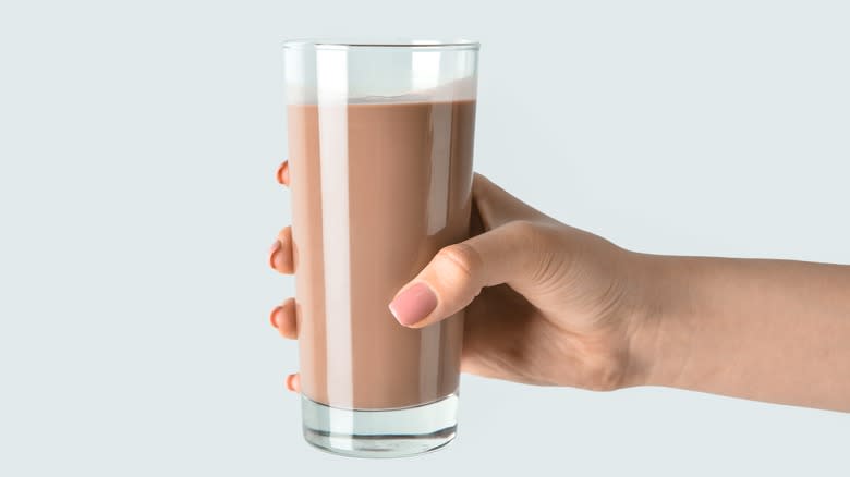 hand holding a glass of chocolate milk