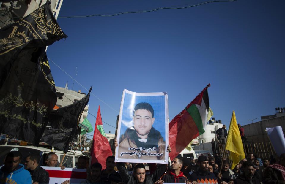 Palestinians hold up a poster of a missing fisherman, Mohammed Al-Hissi, 33, as they attend his symbolic funeral in Gaza City, Saturday, Jan. 7, 2017. The family of a Palestinian fisherman who disappeared after boat collision with an Israeli navy vessel off Gaza coast declared him dead Saturday after three days of search, accusing the Israeli military of deliberately sinking the fishing boat. (AP Photo/Khalil Hamra)