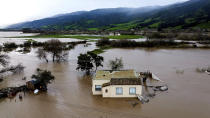 Floodwaters surround a home in the Chualar community of Monterey County, Calif., as the Salinas River overflows its banks on Friday, Jan. 13, 2023. (AP Photo/Noah Berger)