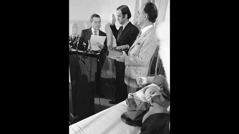 Beau Biden, foreground, plays near his father as he is sworn in as a senator from Delaware by Senate Secretary Frank Valeo