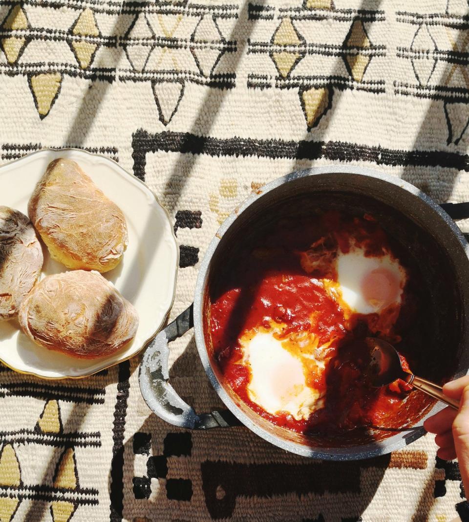 Making shakshuka in a pot with bread on the side.