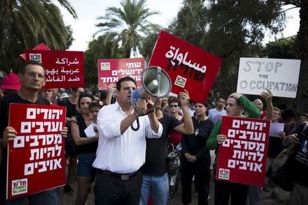 Ayman Odeh (C), leader of the Joint Arab list, and Dov Khenin (L), a fellow party member and member of parliament, take part in a left-wing protest in light of recent Palestinian-Israeli violence in Tel Aviv, Israel October 9, 2015. REUTERS/Amir Cohen