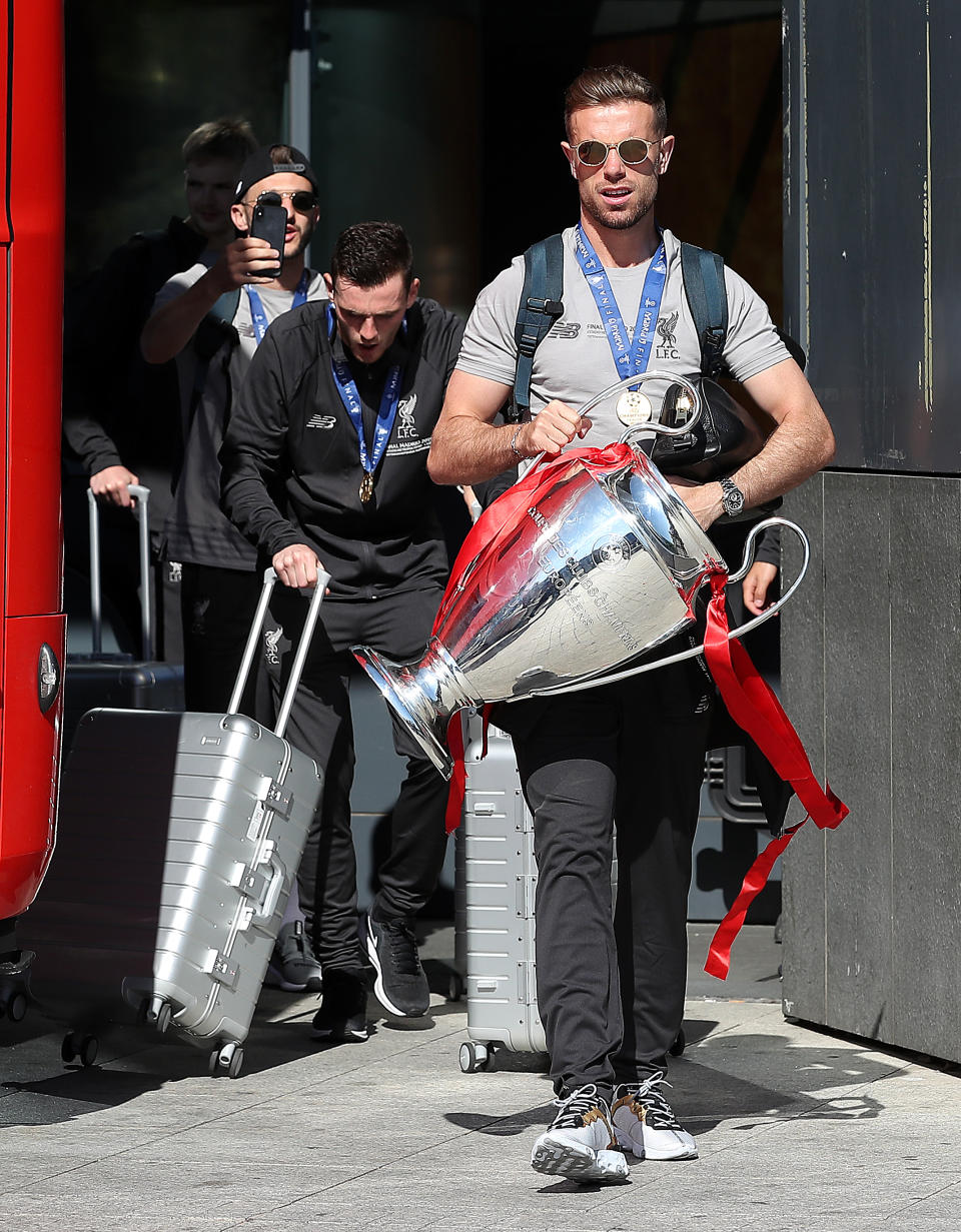 Liverpool captain Jordan Henderson leaves the Eurostars Madrid Tower Hotel holding the Champions League trophy, as the team travel home for a homecoming parade.