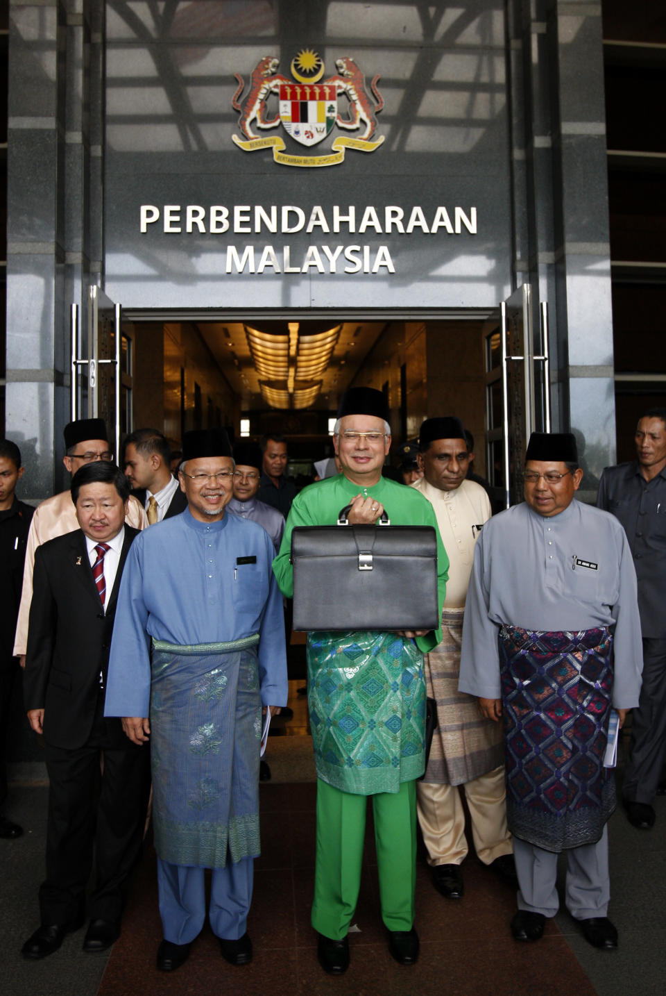 Malaysian Prime Minister and Finance Minister Najib Razak, center, holds a briefcase as he poses with Finance Minister II Ahmad Husni Mohamad Hanadzlah, second from left, Deputy Finance Minister Awang Adek, right, and Deputy Finance Minister Donald Lim before he leaves from Finance Ministry office in Putrajaya, Malaysia, Friday, Sept. 28, 2012, to Parliament House to unveil the Malaysia's 2013 budget. (AP Photo/Lai Seng Sin)