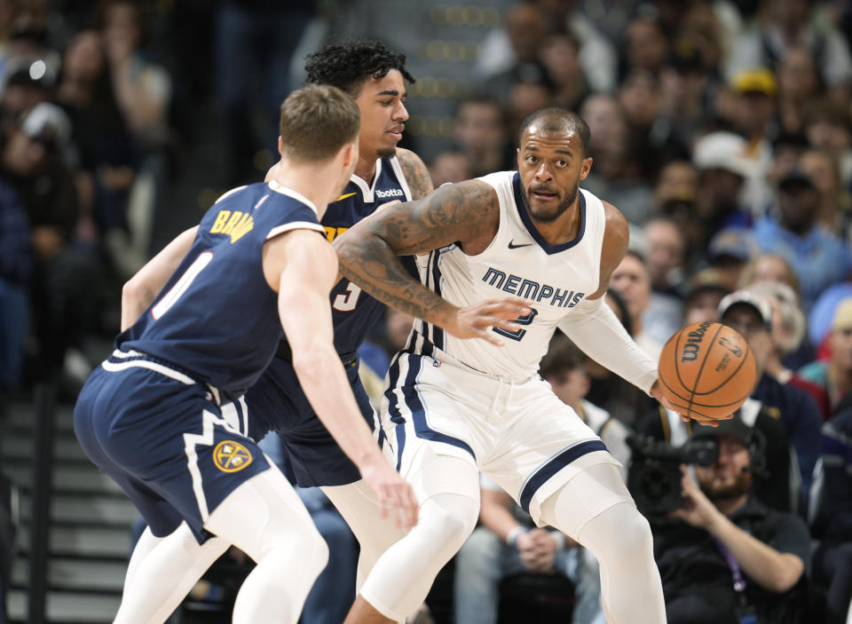Memphis Grizzlies forward Xavier Tillman, right, is trapped with the ball by Denver Nuggets guards Christian Braun, front left, and Julian Strawther, back left, in the first half of an NBA basketball game Thursday, Dec. 28, 2023, in Denver. (AP Photo/David Zalubowski)