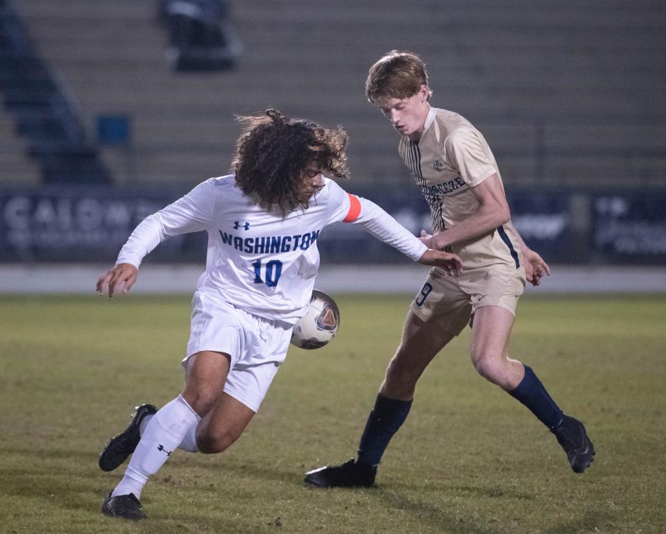 Kyle Hunnicutt (10) and Noah Flint (19) fight for a loose ball during the Booker T. Washington vs Gulf Breeze boys soccer game at Gulf Breeze High School on Thursday, Jan. 11, 2024.