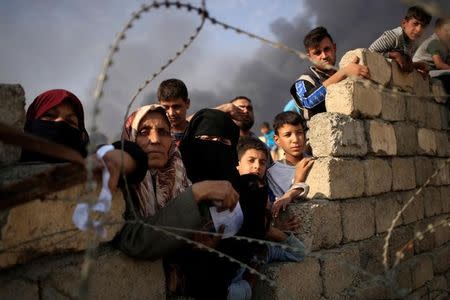 Newly displaced people wait as they complain about what they say is a lack of humanitarian aid outside the processing center in Qayyara, south of Mosul, Iraq October 25, 2016. REUTERS/Zohra Bensemra