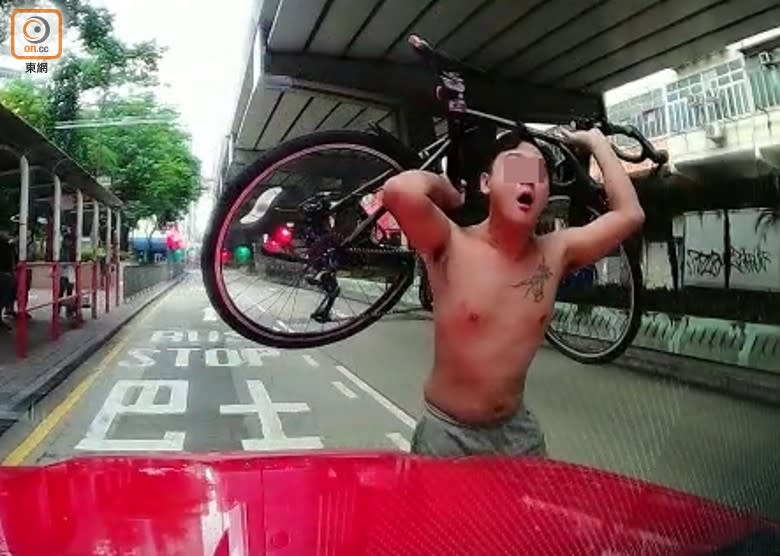 單車男作勢舉起單車掟向的士。