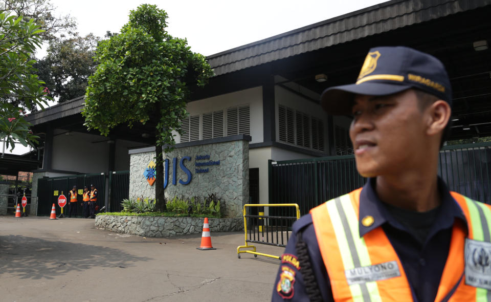 In this Thursday, May 8, 2014 photo, a security guard stands at the entrance of Jakarta International School (JIS) compound in Jakarta, Indonesia. U.S. citizen William Vahey taught here from 1992-2002. Vahey began his international teaching career with a series of stays around the Middle East and Europe, and by 1992, Vahey and his wife moved to Indonesia. He was one of the most beloved teachers in the world of international schools that serve the children of diplomats, well-off Americans and local elites. That was the public persona of William Vahey until a maid stole a memory drive from him in November. On it was evidence that Vahey molested scores of adolescent boys, possibly more. (AP Photo/Achmad Ibrahim)