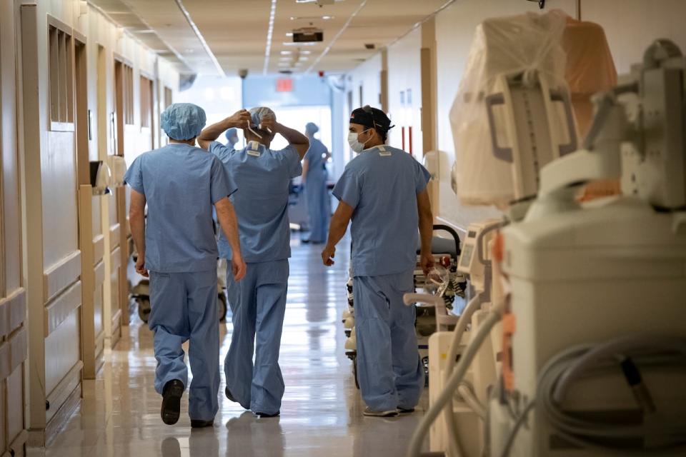 Surgical oncologists Dr. Usmaan Hameed, right, and Dr. Peter Stotland, left, walk to the operating room at North York General Hospital on May 26, 2020. Doctors are adjusting to a new normal that includes reduced workloads as a result of safety protocols established during the COVID-19 pandemic 