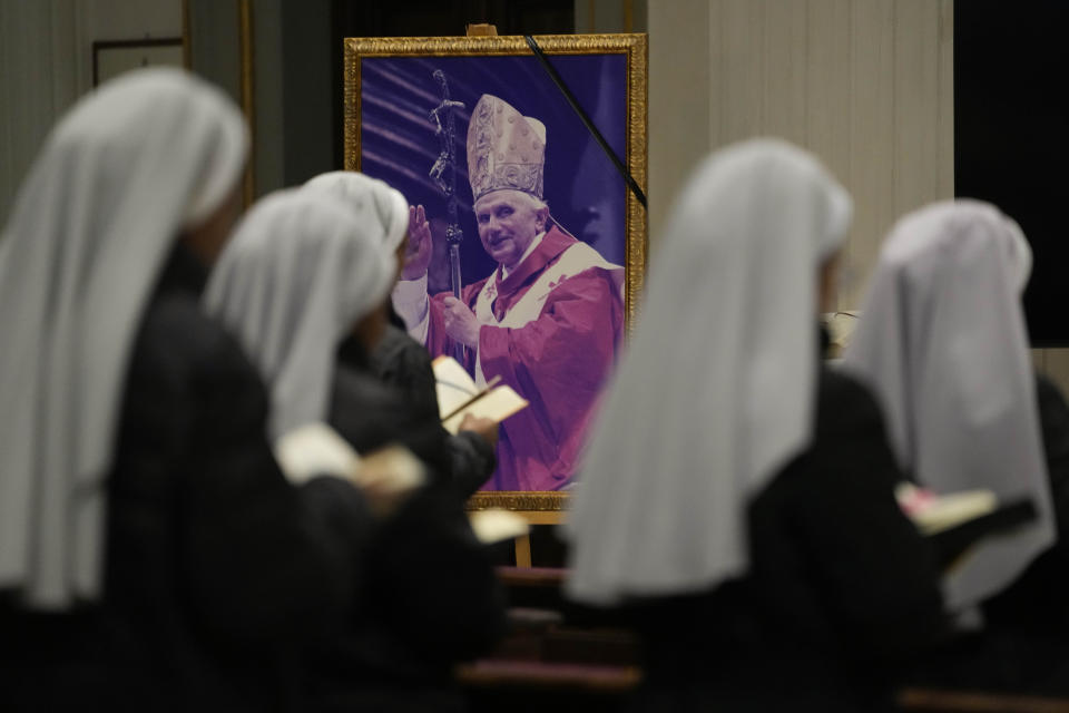A photo of late Pope Emeritus Benedict XVI is displayed during a mass in the San Tommaso Da Villanova Parrish church in Castel Gandolfo, where Pope Emeritus Benedict XVI made his last public blessing as pope in 2013, in the hills south of Rome, Tuesday Jan. 3, 2023. Benedict XVI's death has hit Castel Gandolfo's "castellani" particularly hard, since many knew him personally, and in some ways had already bid him an emotional farewell when he uttered his final words as pope from the palace balcony overlooking the town square. (AP Photo/Alessandra Tarantino)