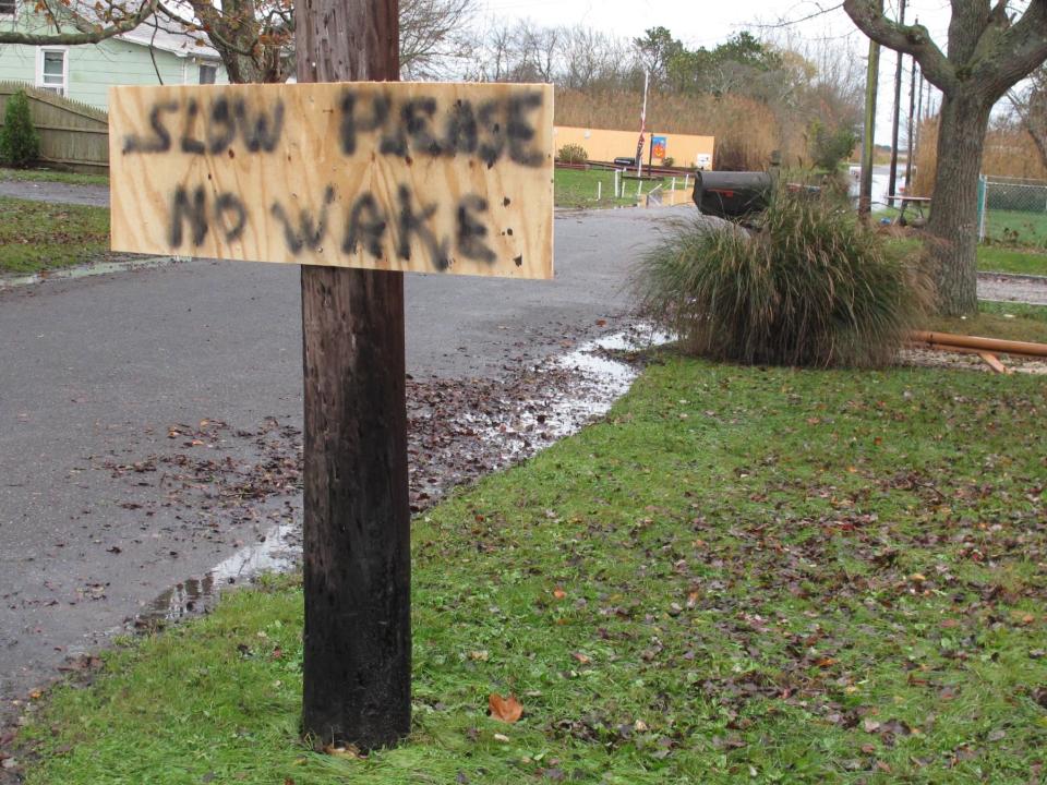 A Magnolia Avenue posted a sign asks drivers to move down the street with caution before floodwaters began to recede on Wednesday, Oct. 31, 2012, in Mastic Beach, N.Y. A spokeswoman for Suffolk County Executive Steve Bellone said Mastic Beach was one of the hardest hit communities on the south shore of Long Island during the storm.(AP Photo/Frank Eltman)