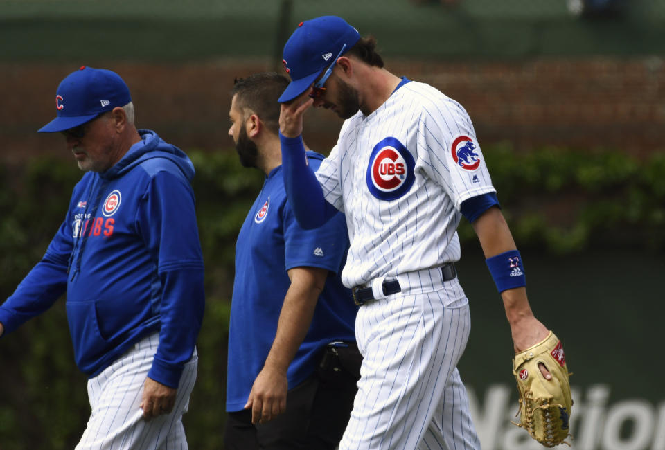 Chicago Cubs right fielder Kris Bryant, right, walks off the field with Chicago Cubs manager Joe Maddon, left, after he was injured during the sixth inning of a baseball game against the Cincinnati Reds Sunday, May 26, 2019, in Chicago. (AP Photo/Matt Marton)