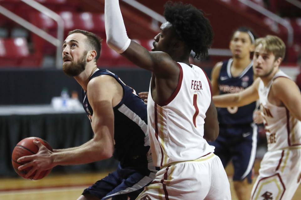 Virginia's Jay Huff, left, looks to shoot against Boston College's CJ Felder (1) during the first half of an NCAA college basketball game, Saturday, Jan. 9, 2021, in Boston. (AP Photo/Michael Dwyer)