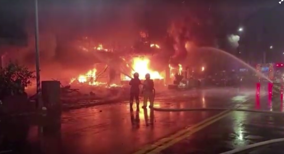 Two firefighters work at the base of the building. Source: Reuters