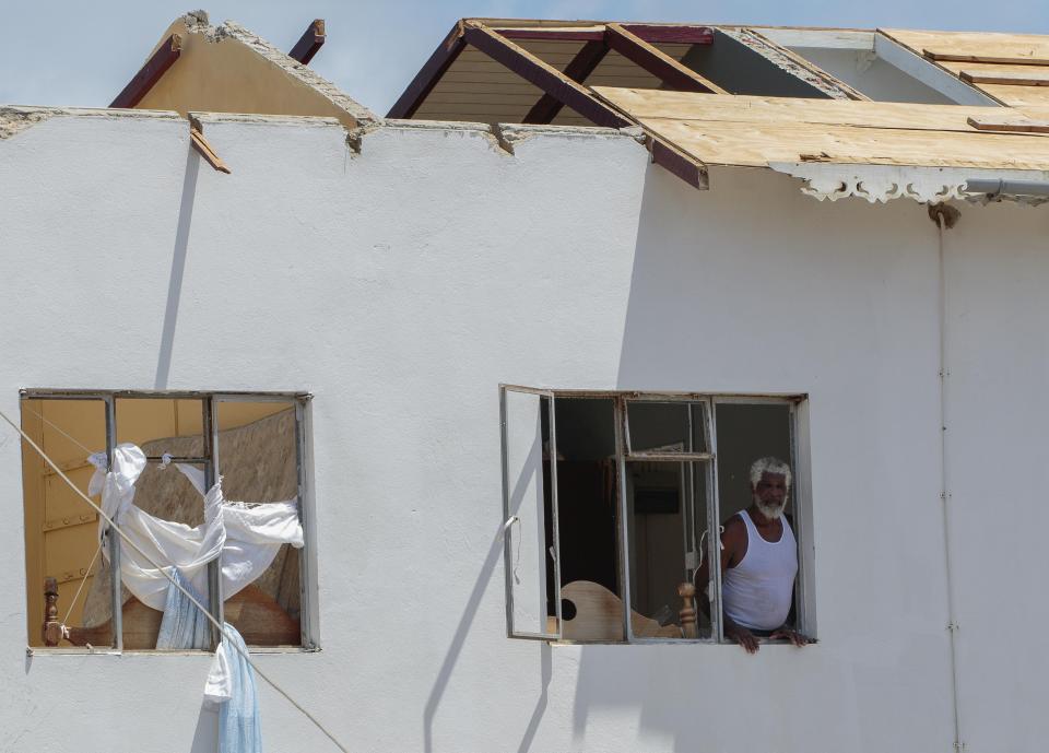 A man looks out of the window of his home, which was destroyed by Hurricane Beryl in Clifton, Union Island, St. Vincent and the Grenadines, Thursday, July 4, 2024. (AP Photo/Lucanus Ollivierre)