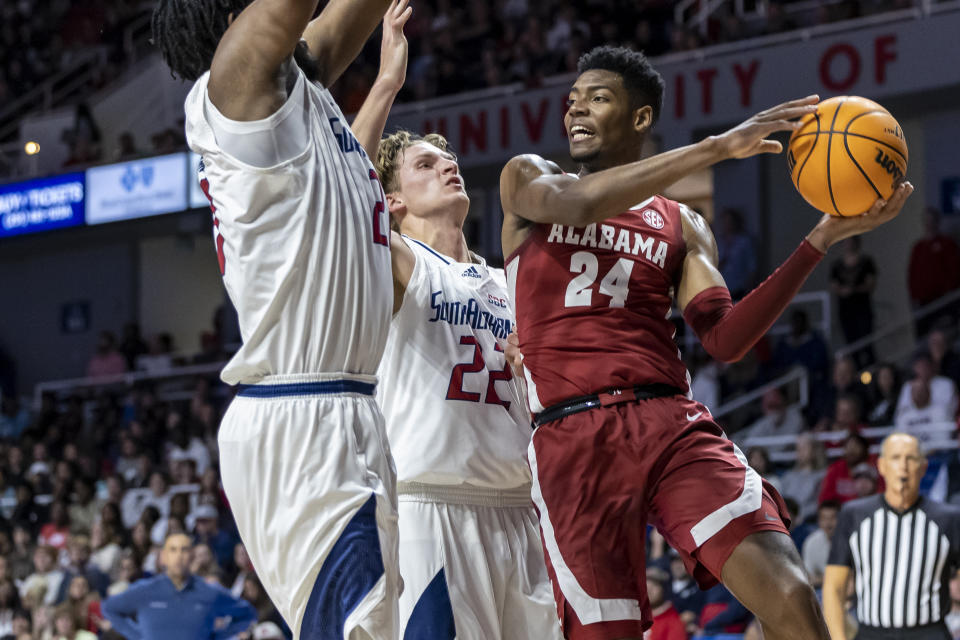 Alabama forward Brandon Miller (24) works against South Alabama center Kevin Samuel (21) and guard Owen White (22) during the first half of an NCAA college basketball game Tuesday, Nov. 15, 2022, in Mobile, Ala. (AP Photo/Vasha Hunt)