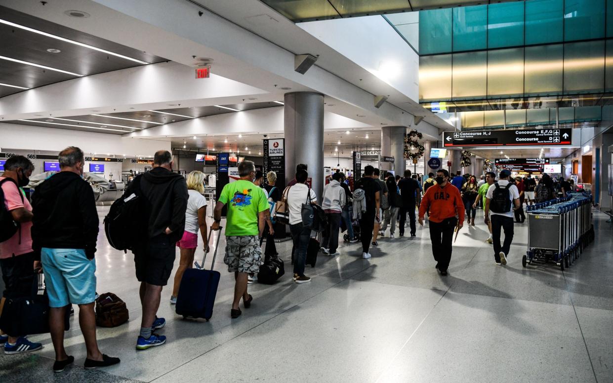 People wait in line at the Miami International Airport