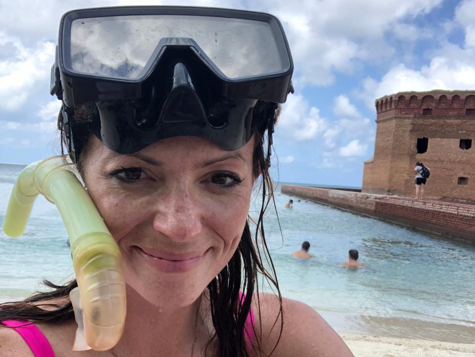 Emily takes a selfie while wearing a pink bathing suit and snorkel mask.