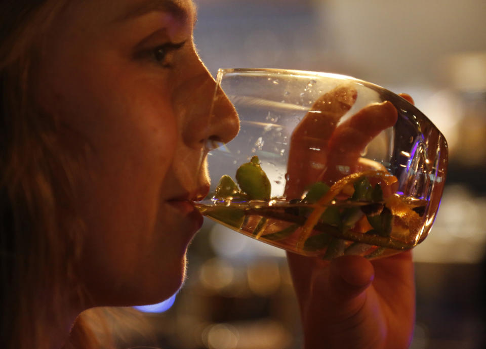 Elsabe Hanekom takes part in a gin tasting session at the Botlierskop Private Game Reserve, near Mossel Bay, South Africa, Monday, Oct. 23, 2019. After about five sizeable bags of dung are collected for a batch of 3,000 to 4,000 bottles of the gin, the droppings are dried and crumbled, then washed to remove dirt and sand. Eventually only the remains of the fruits, flowers, leaves and bark eaten by the elephants are left behind. (AP Photo/Denis Farrell)