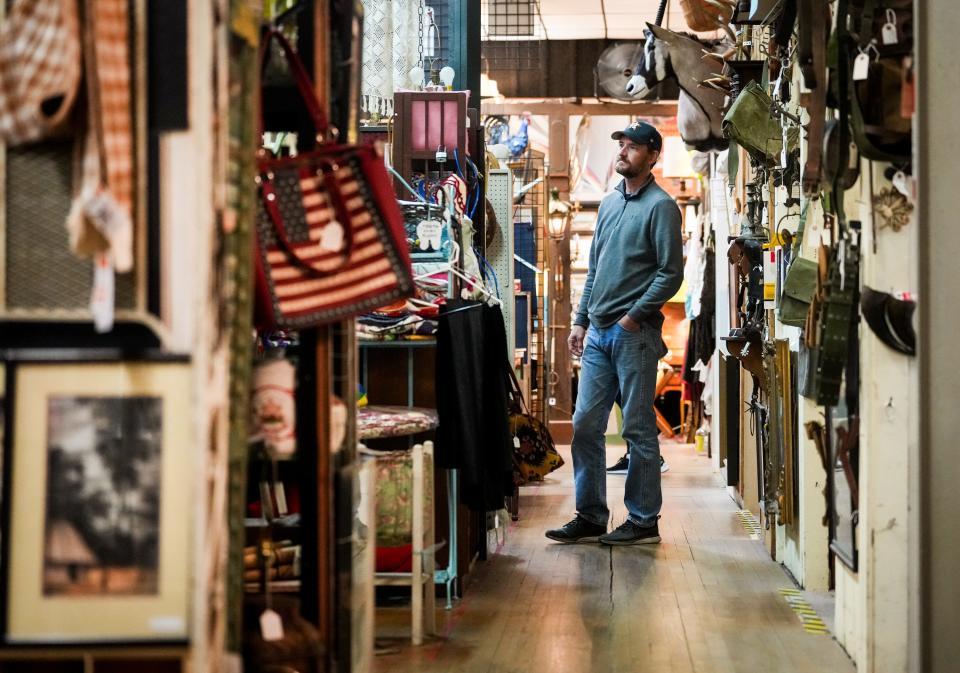 Shopper Eric Gaskamp browses the aisles at the Austin Antique Mall. Gaskamp is hoping to furnish his home mainly from thrift and antique stores.