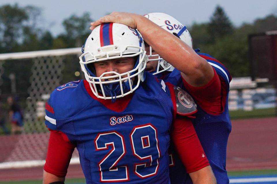 Highland's Owen Stillwell (29) and Dane Nauman celebrate a play during a football game with Pleasant earlier this season.