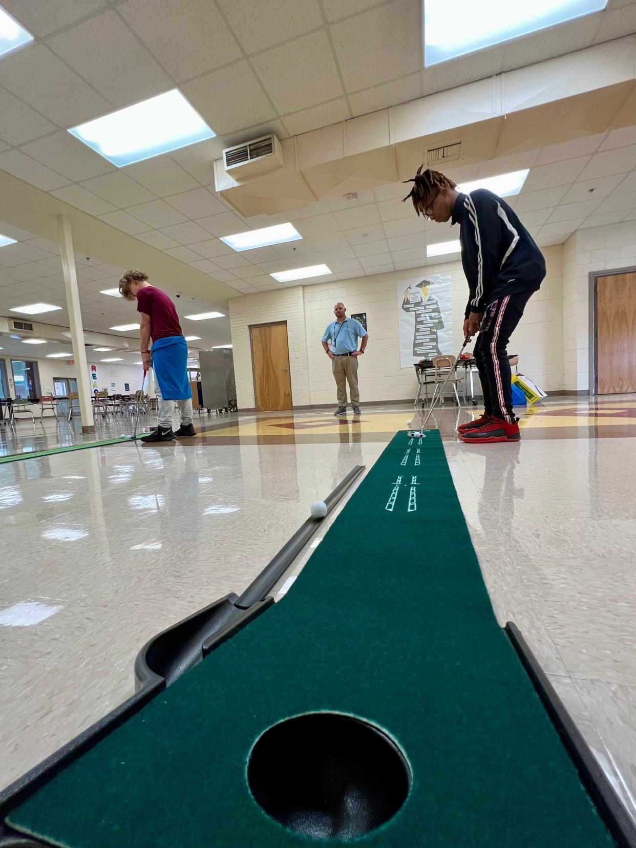 Jermetris Jackson and Cooper Weaver practice putting at Turning Point Academy on Thursday.