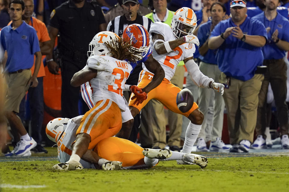 Florida wide receiver Jacob Copeland, center, fumbles as he is hit by Tennessee linebacker Jeremy Banks (33) and defensive back Alontae Taylor (2) during the first half of an NCAA college football game, Saturday, Sept. 25, 2021, in Gainesville, Fla. Tennessee recovered the ball. (AP Photo/John Raoux)