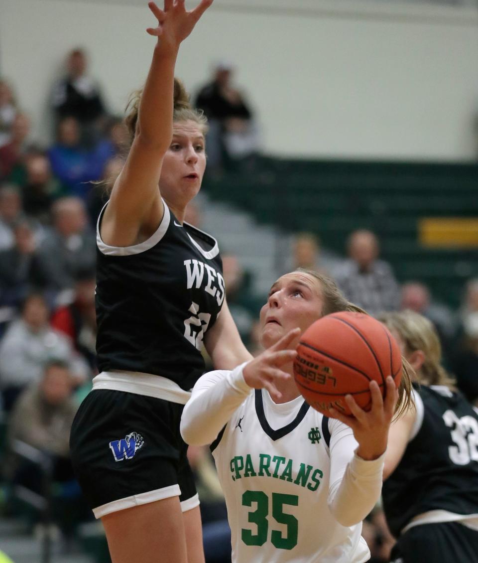 Oshkosh North's Mallory Ott, right, tries to get off a shot against Oshkosh West's Paige Seckar during their Fox Valley Association girls basketball game Friday at Oshkosh North.