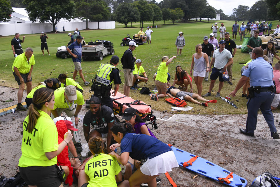 Spectators are tended to after a lightning strike on the East Lake Golf Club course left several injured during a weather delay in the third round of the Tour Championship golf tournament Saturday, Aug. 24, 2019, in Atlanta. (AP Photo/John Amis)