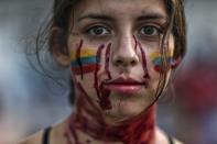 A student performs a play called "Who killed them" during anti-government protests in Cali, Colombia, Tuesday, May 11, 2021. Colombians have protested across the country against a government they feel has long ignored their needs, allowed corruption to run rampant and is so out of touch that it proposed tax increases during the coronavirus pandemic. (AP Photo/Andres Gonzalez)