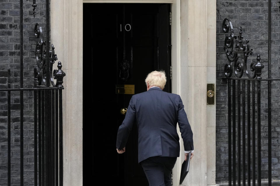 Prime Minister Boris Johnson walks back inside after reading a statement outside 10 Downing Street, London, formally resigning as Conservative Party leader, in London, Thursday, July 7, 2022. Johnson said Thursday he will remain as British prime minister while a leadership contest is held to choose his successor. (AP Photo/Frank Augstein)