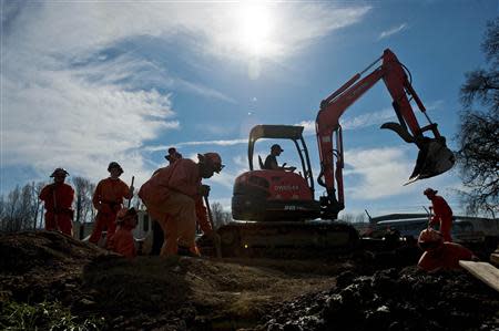 Prison laborers and an excavator operator help construct an emergency pipeline to increase supplies of potable water in Willits, California February 25, 2014. REUTERS/Noah Berger