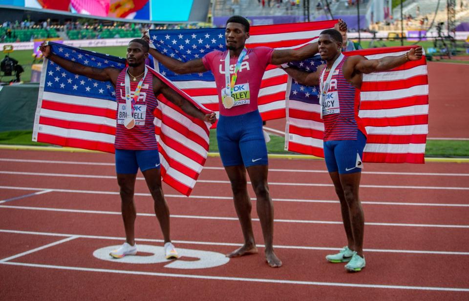Fred Kerley, center, Marvin Bracy, right, and Trayvon Bromell, left, celebrate after finishing 1-2-3 in the 100-meter final.