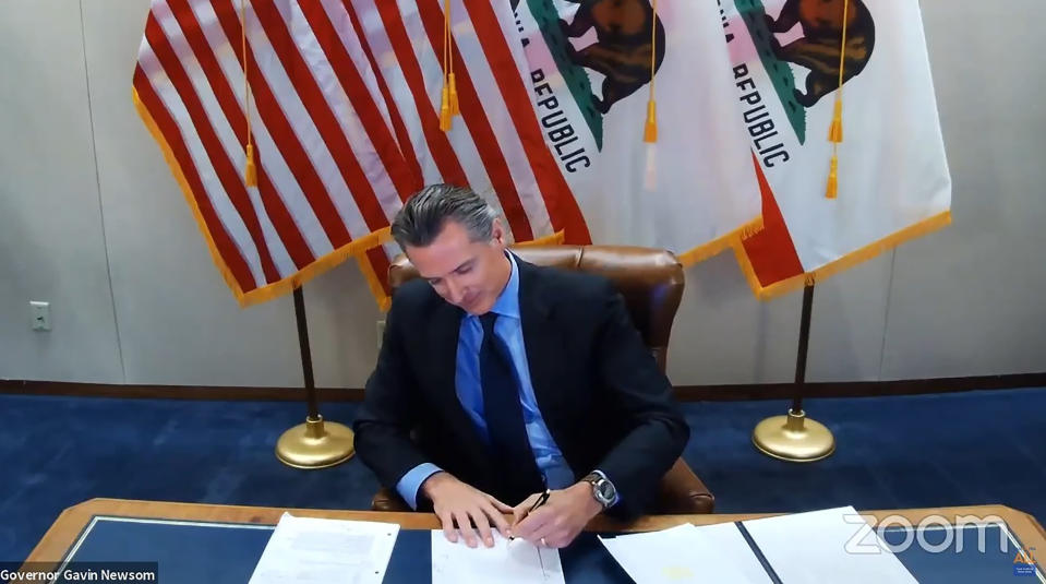 FILE - In this image made from video from the Office of the Governor California Gov. Gavin Newsom signs into law a bill that establishes a task force to come up with recommendations on how to give reparations to Black Americans on Sept. 30, 2020, in Sacramento, Calif. A report by California's first in the nation task force on reparations Wednesday, June 1, 2022, will document in detail the harms perpetuated by the state against Black people and recommend ways to address those wrongs. (Office of the Governor via AP, File)