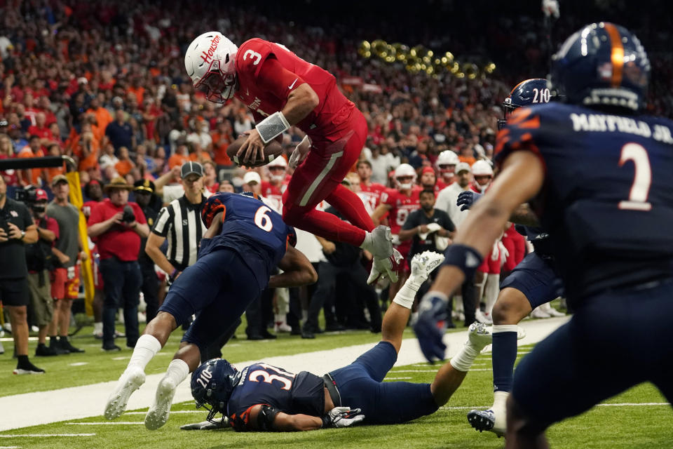 Houston quarterback Clayton Tune (3) leaps over UTSA safety Kelechi Nwachuku (6) to score during overtime in an NCAA college football game Saturday, Sept. 3, 2022, in San Antonio. (AP Photo/Eric Gay)