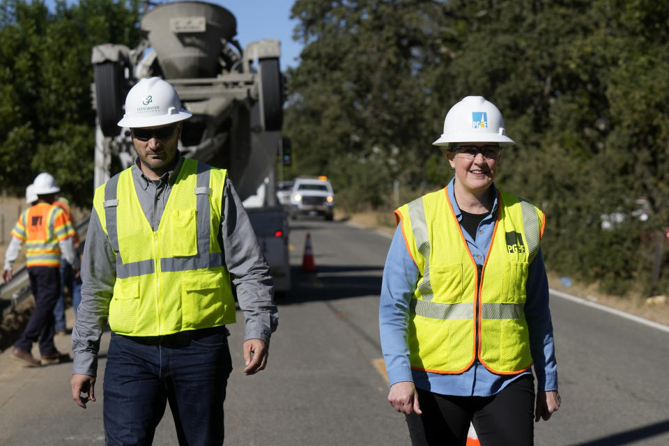 Pacific Gas and Electric CEO Patti Poppe, right, walks with project manager Jeremy Schanaker during a tour of PG&E workers burying power lines in Vacaville, Calif., Wednesday, Oct. 11, 2023. (AP Photo/Jeff Chiu)