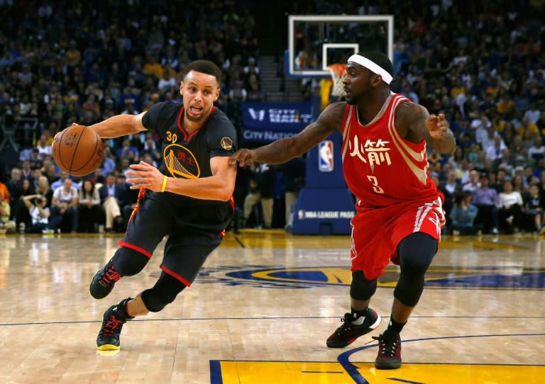 Stephen Curry of the Golden State Warriors (L) drives past Ty Lawson of the Houston Rockets at ORACLE Arena in Oakland, California on February 9, 2016