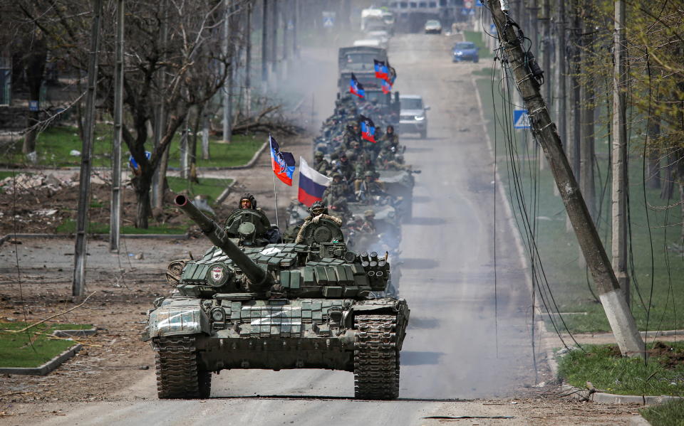 An armored convoy of pro-Russian troops moves along a road in the port city of Mariupol, Ukraine.