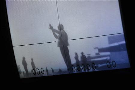 A screen shows a flight deck crew member signalling to direct the take off of a U.S. Navy F/A-18 aircraft on the deck of the U.S. Navy aircraft carrier USS George Washington, during a tour of the ship in the South China Sea November 7, 2013. REUTERS/Tyrone Siu