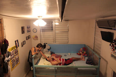 Ramona Febo-Boarman caresses her son Joey while he is lying in his bed at their home in Bayamon, Puerto Rico, December 1, 2016. REUTERS/Alvin Baez