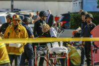 <p>An unidentified woman is helped by paramedics at a triage area after a gunman barricaded himself inside a Trader Joe’s store in Los Angeles on Saturday. (Photo: Damian Dovarganes/AP) </p>