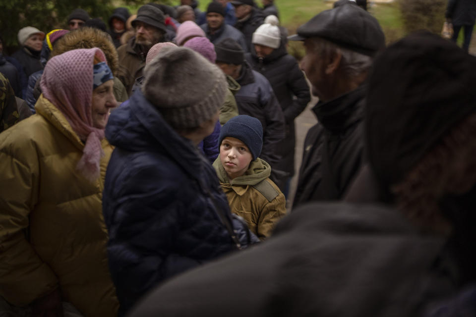 Sergei, 11, waits his turn to receive donated food during an aid humanitarian distribution in Bucha, in the outskirts of Kyiv, on Tuesday, April 19, 2022. Citizens of Bucha are still without electricity, water and gas after more than 44 days since the Russian invasion began. (AP Photo/Emilio Morenatti)