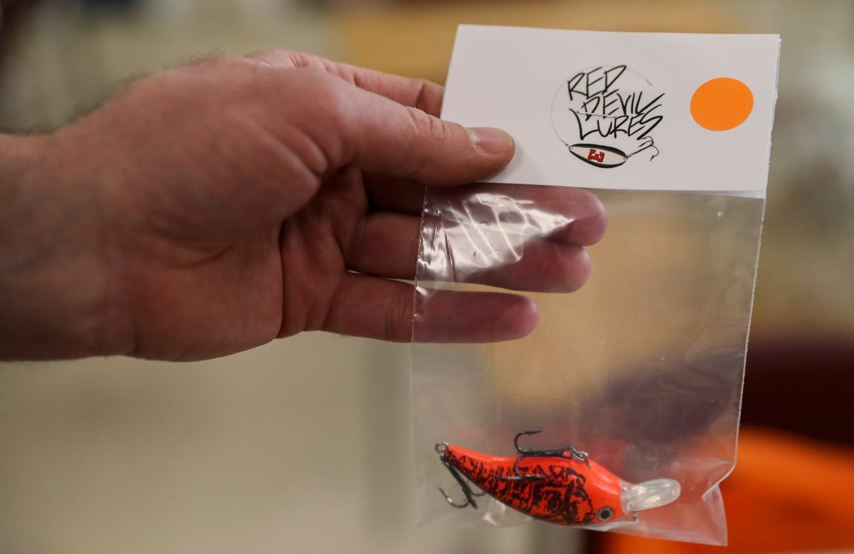 Green Bay East High School teacher Brian Fisk shows a refurbished fishing lure. Fisk hunts for lost fishing lures and line in and near waterways in northeast Wisconsin.