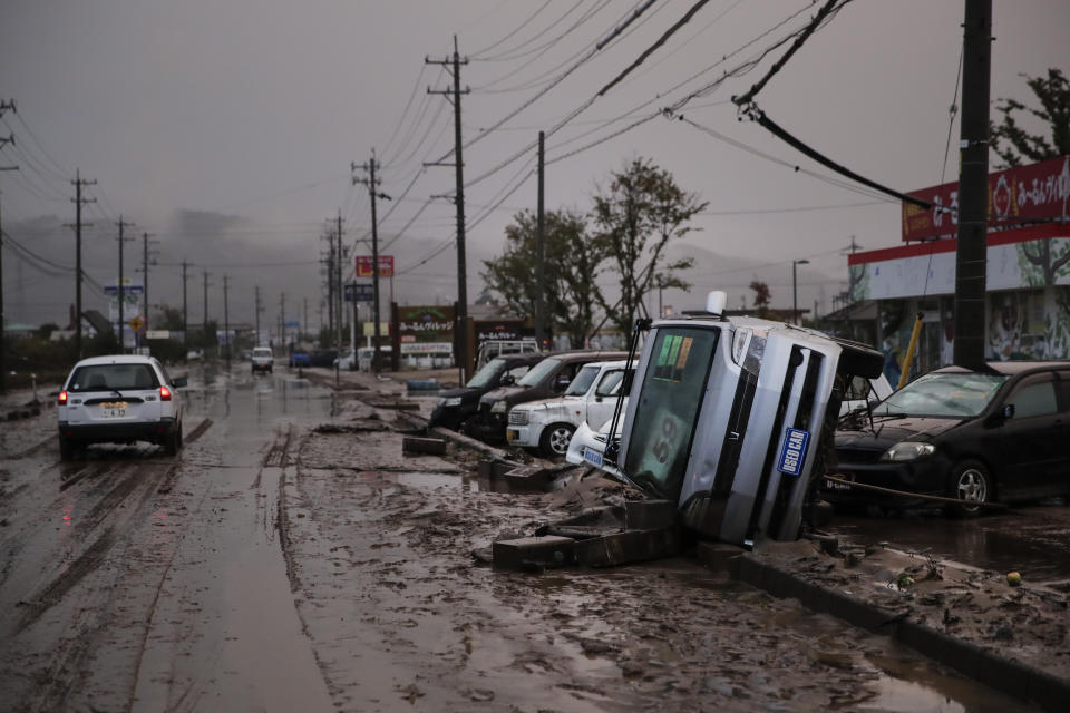 Typhoon-damaged cars sit on the street covered with mud Monday, Oct. 14, 2019, in Hoyasu, Japan. Rescue crews in Japan dug through mudslides and searched near swollen rivers Monday as they looked for those missing from typhoon Hagibis that left as many as 36 dead and caused serious damage in central and northern Japan. (AP Photo/Jae C. Hong)