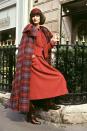 <p>A model from Christian Dior's fall 1977 collection wears a red tweed suit and colorful tartan wool cape.<br></p>