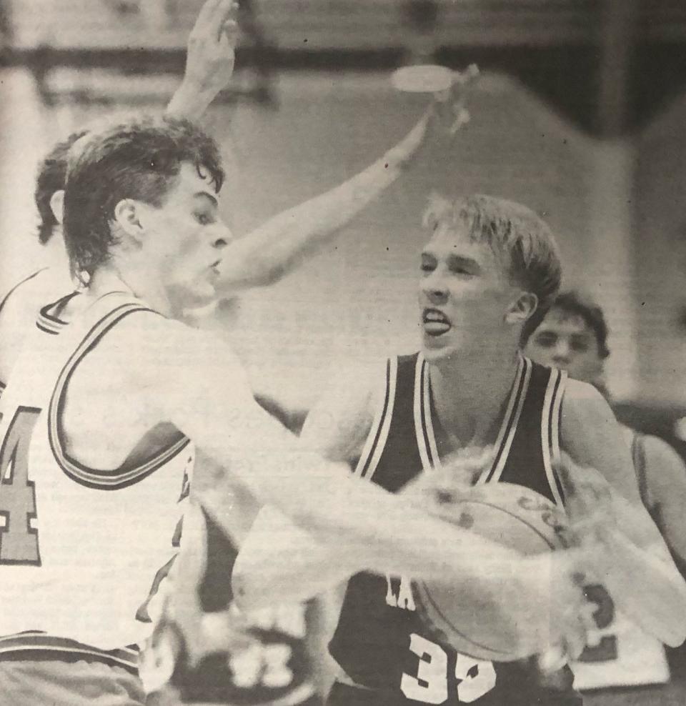 Summit's Chad Steinocker attempts to knock the ball away from Langford's Stuart Franzen during their game in the 1991 Region 1B boys basketball tournament at Webster.